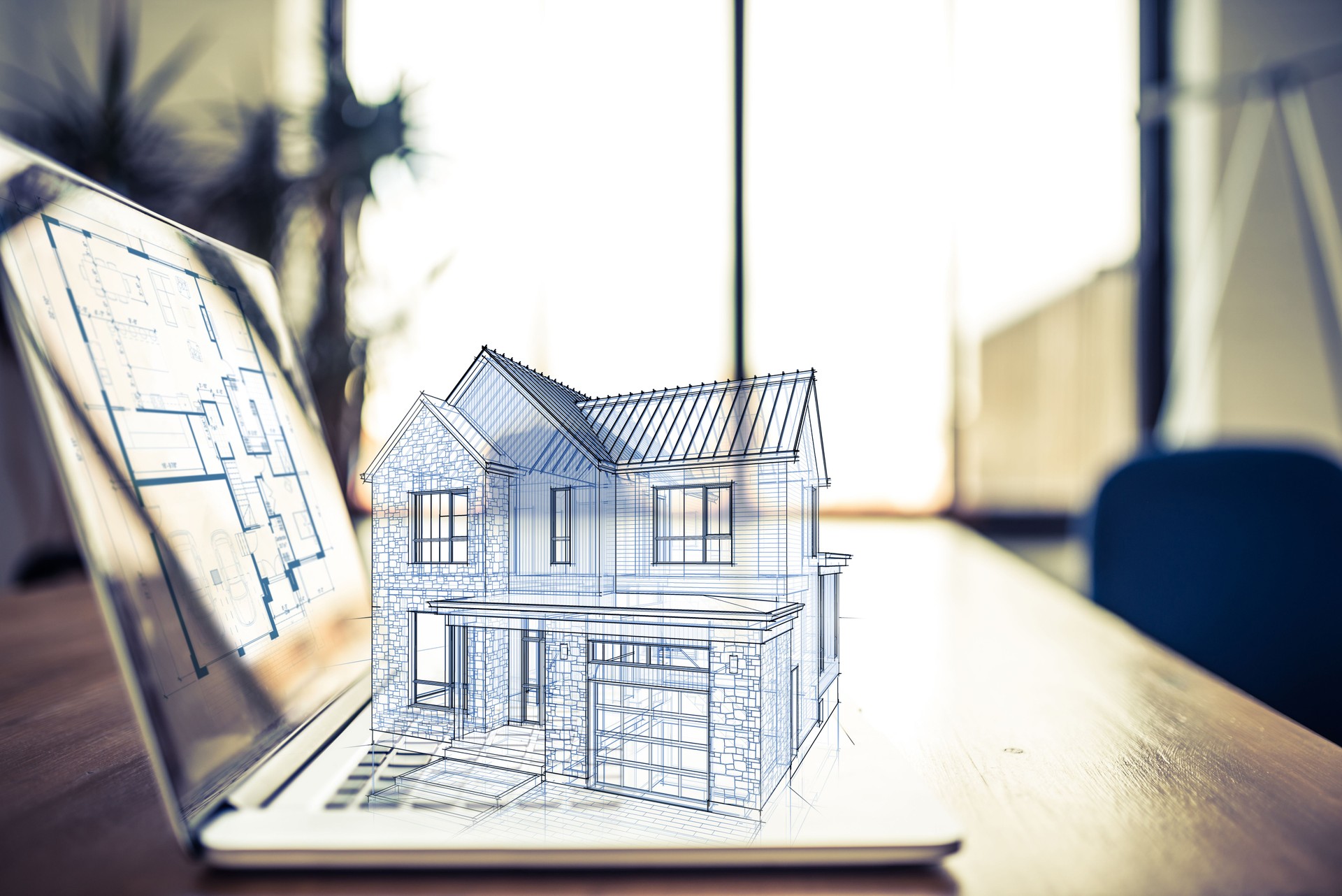 Hologram of a house project over a laptop computer