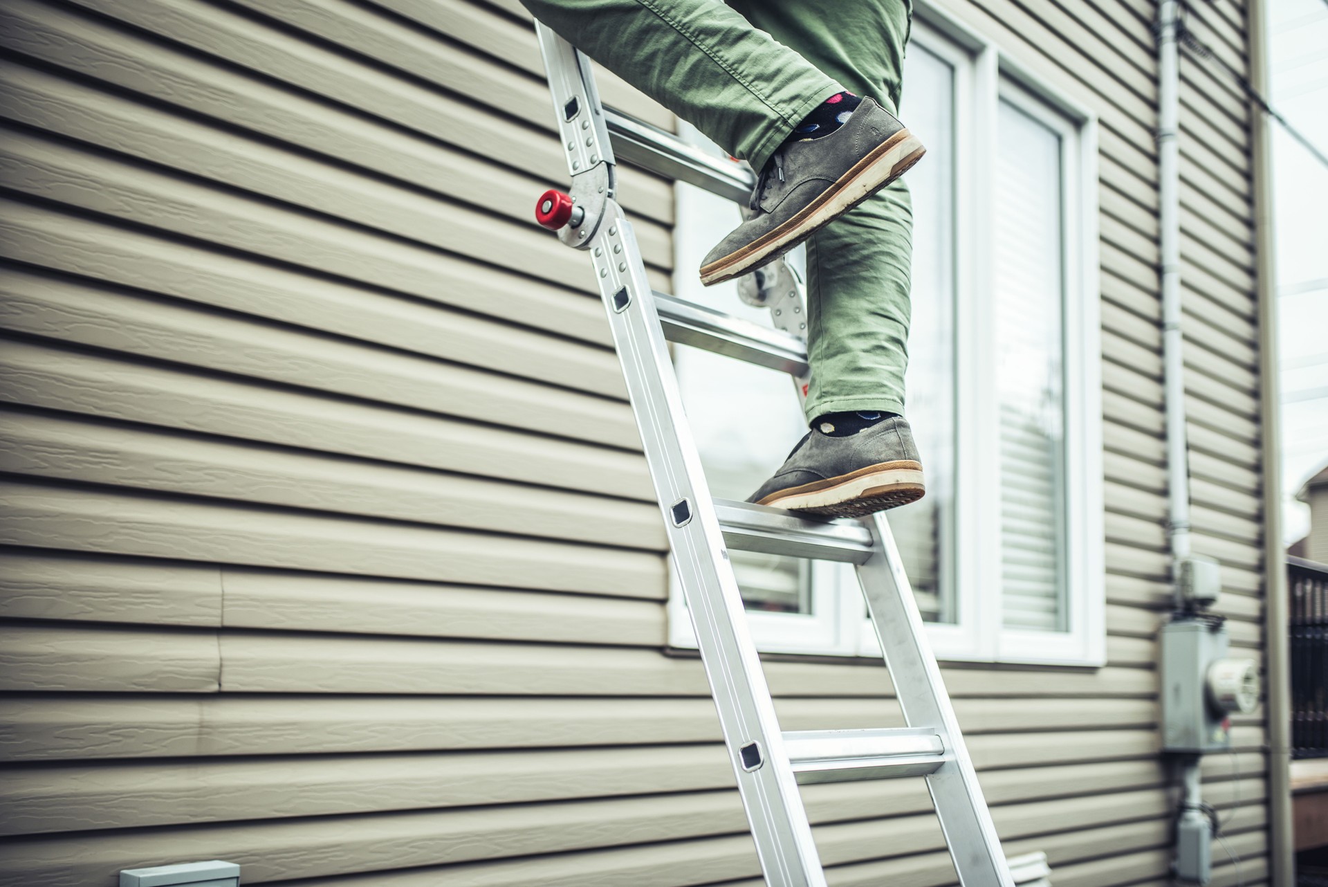 House owner climbing the ladder to inspect the house